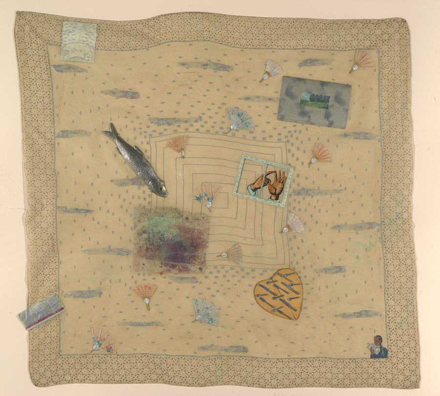 A collage of images and found objects created on a beige silk scarf.