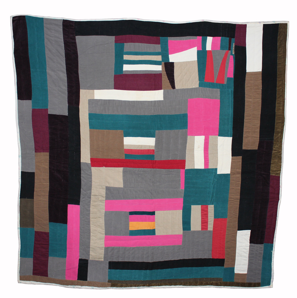 A colorful quilt created with rectangular panels in dark-neutral tones, blue-green, and neon pink.