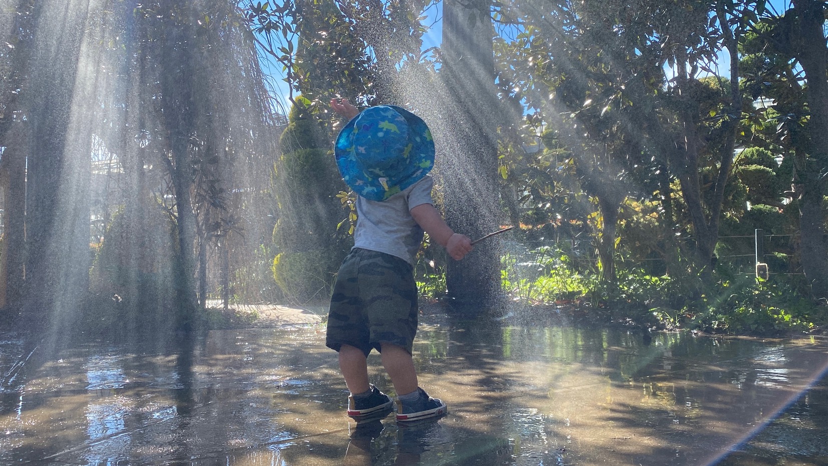 A child reaches for mist in the Children's Garden.