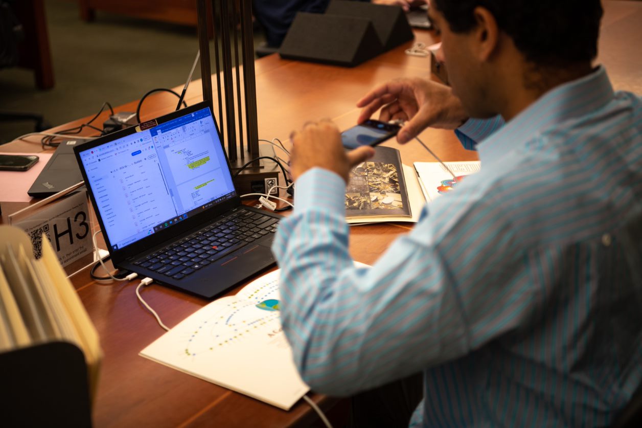 scholar using phone to capture image in reading room materials