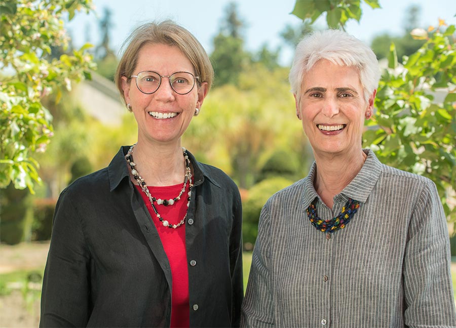 Two people smile at the camera.