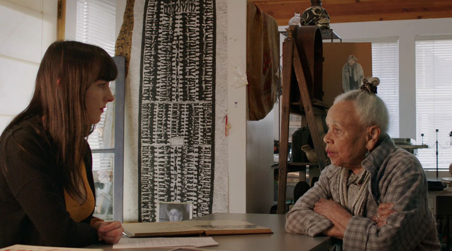 Two people sit at a table, talking.