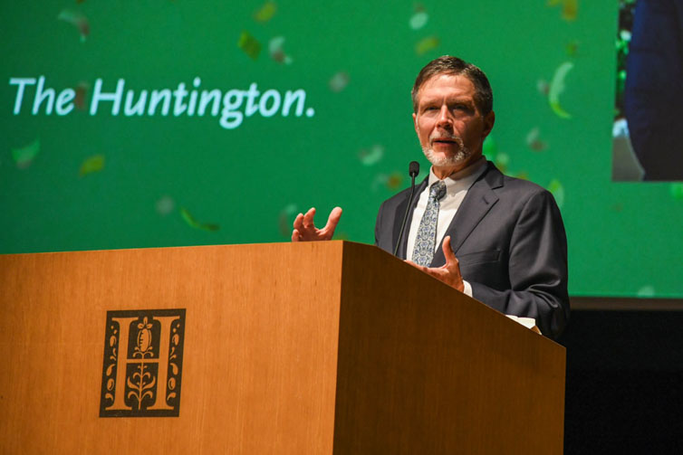 A person stands behind a podium on a stage.