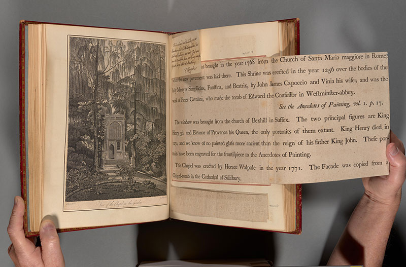 An oversized text foldout is shown in an open book.