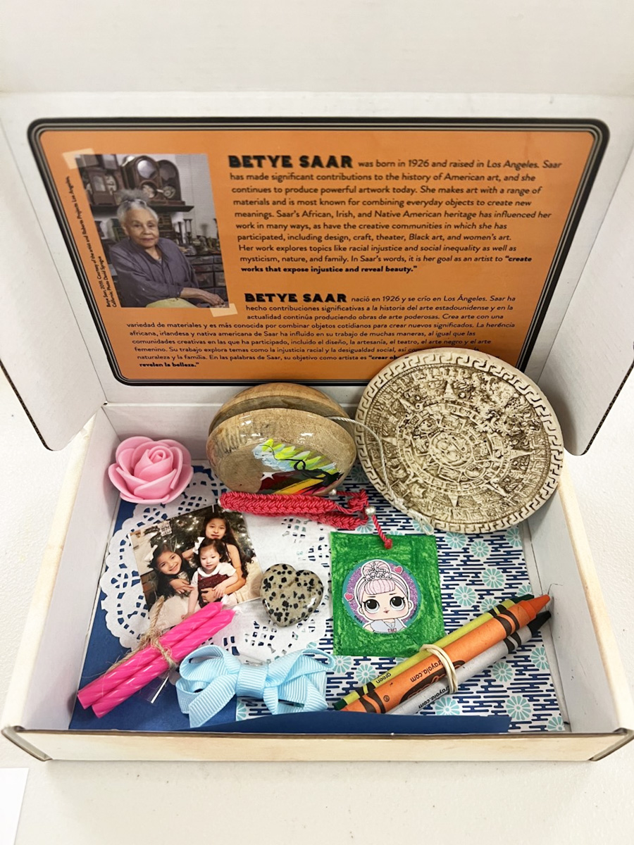 A box filled with various found objects, patterned papers, and a family photo.