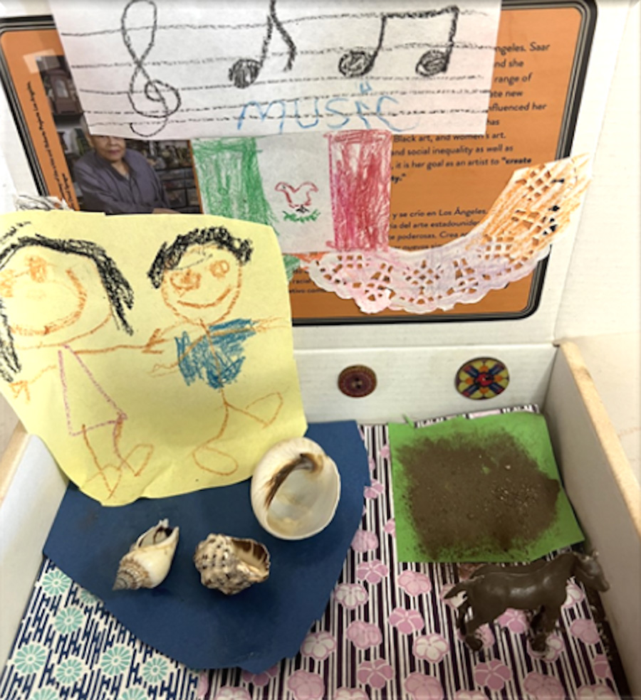 A box filled with various found objects, patterned papers, and drawings.