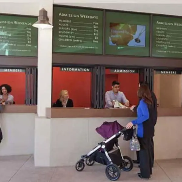 Patrons in front of museum ticket windows.