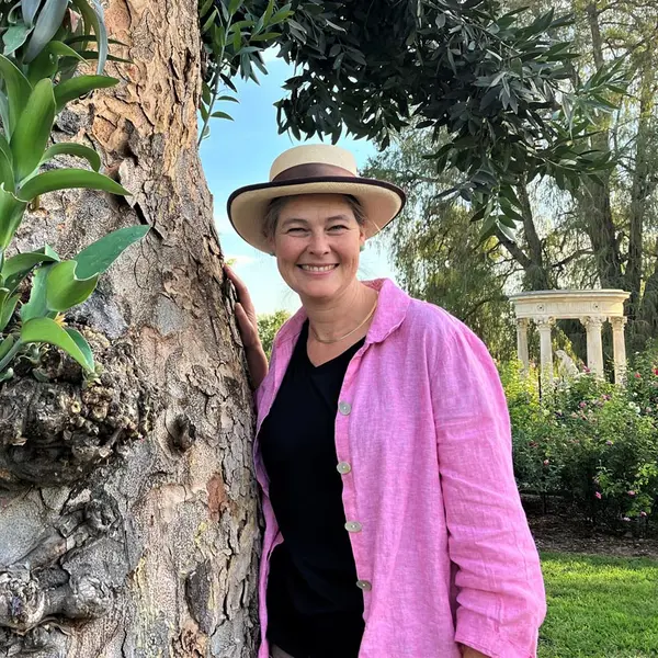 Nicole Cavender stands next to a tree in the Huntington Rose Garden.