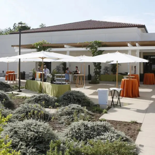 Long shot of cocktail tables under sun umbrellas.	