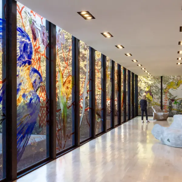 Looking down a glass-walled gallery space with bird painted on windows.