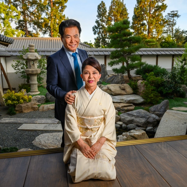 A couple pose in a traditional Japanese home with a large doorway that opens into a garden.