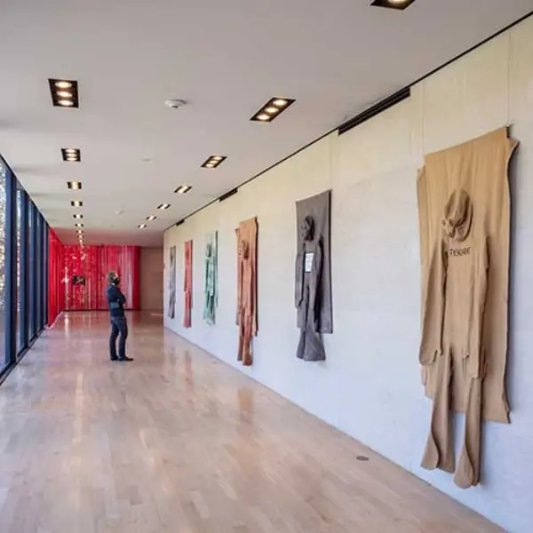 Nicola L.’s Pénétrables are on view in the Rothenberg Loggia of The Huntington’s Virginia Steele Scott Galleries of American Art. Nicola L., [left to right] Pénétrable (Cloud), Pénétrable (Flower), Pénétrable (Forest), Pénétrable (Forest), Pénétrable (We Don’t Want War), Pénétrable (Terre), 1970–78, dyed canvas, marker, wood. Nicola L. Estate. Photo by Joshua White.