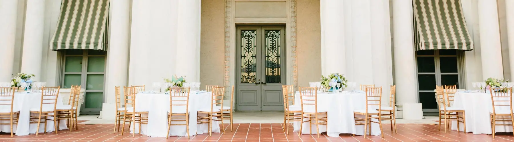 A row of freshly decorated round tables adorn a red tile terrace.