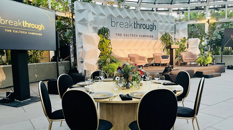 Round event table set up in front of a video monitor and low stage.