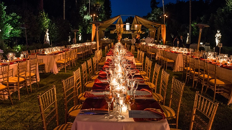 Long rows of tables set up for an outdoor dinner party.