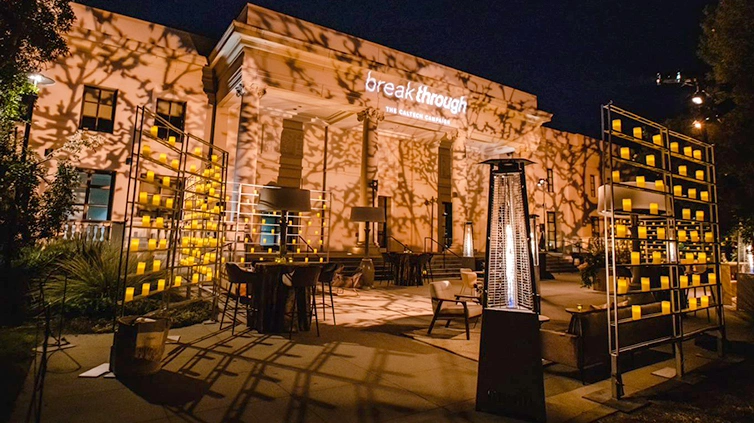 Floral projections light up a building facade while Modern furniture accents the courtyard at night.