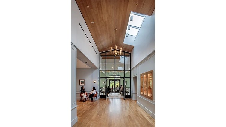 A restaurant foyer with high ceilings and complimentary wood floor and wood ceiling.