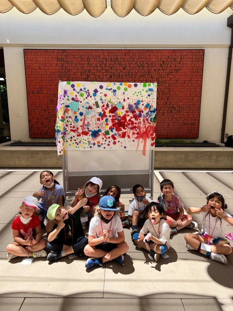 young kids making faces in front of artwork