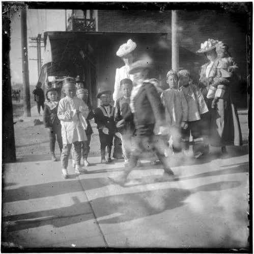 Group of Chinese children outside with two women.