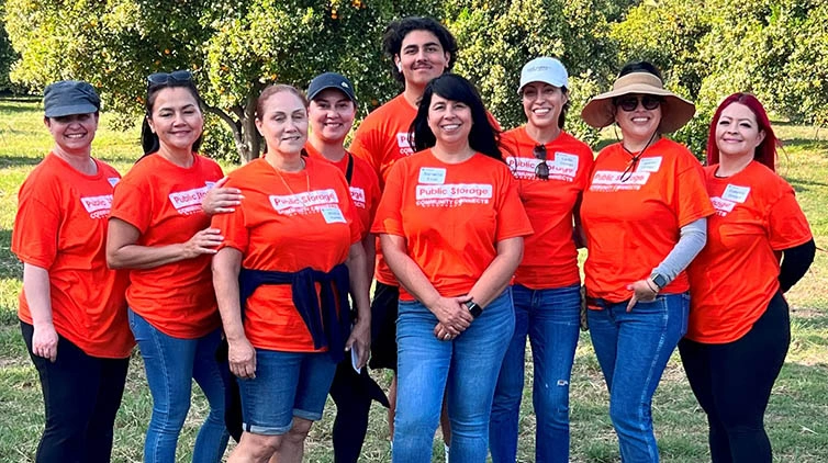 A group of people wearing tee shirts with the Public Storage logo.