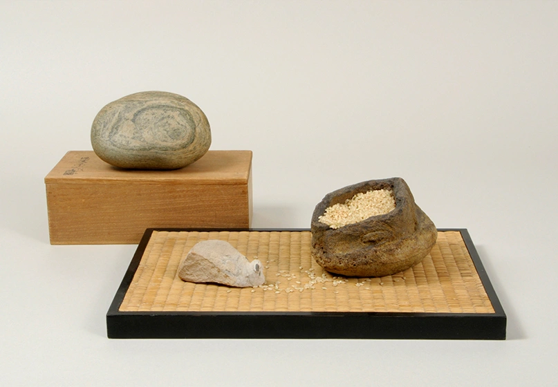 A small group of viewing stones, one resembles a white mouse, another looks like an open bag filled with grains of sand.