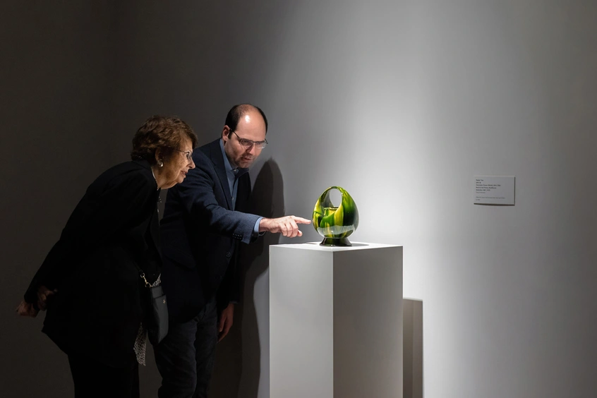 Two people look at artwork in a gallery.