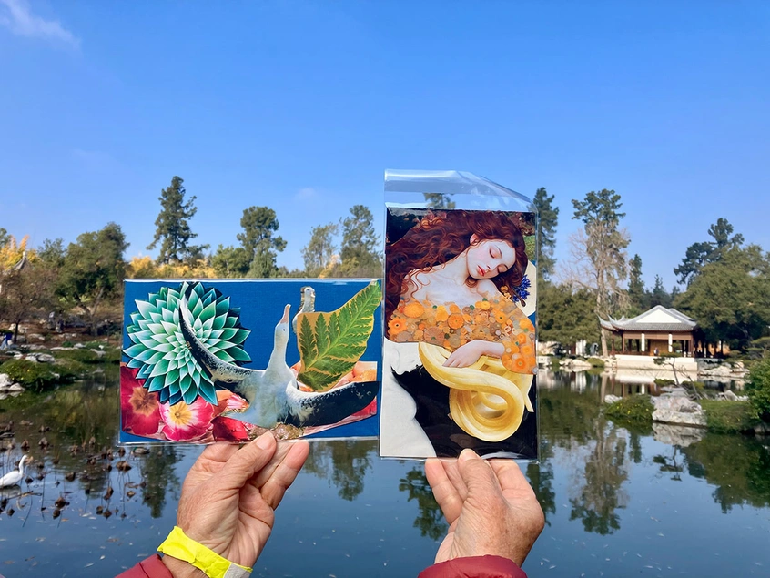 Hands hold up two small collages in front a Chinese garden lake.