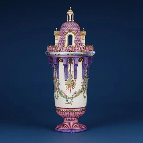 Decorative pink and white ceramic vase resembling an ornate castle