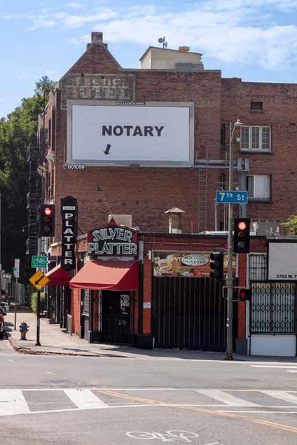 Larry Johnson, Notary, 2020. Billboard at South Rampart Boulevard and West Seventh Street, Los Angeles 90057 (facing north). 144 × 288 in. (365.8 × 731.5 cm). Courtesy of the artist, David Kordansky Gallery, Los Angeles, and 303 Gallery, New York. Installation view, Made in L.A. 2020: a version. Photo: Joshua White / JWPictures.com