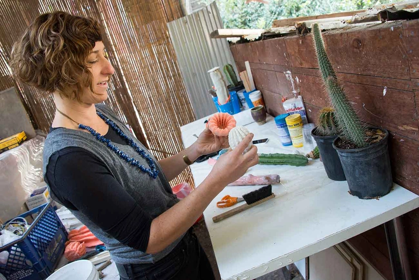 In her outdoor studio, Zya S. Levy peels the latex mold from a plaster cast of a cactus.