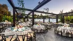 Tables set up under an open wooden canopy.