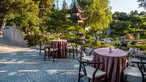 Round tables with rose-colored tablecloths set up around a courtyard.