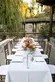 A long table is set up with a white tablecloth and chairs.