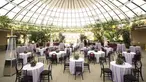 A wide angle shot of small round tables set up under a glass dome.