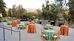 A courtyard filled with party tables covered in teal blue and darker peach tableclothes.