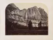 A black-and-white photograph of a mountain range with a waterfall in the middle.