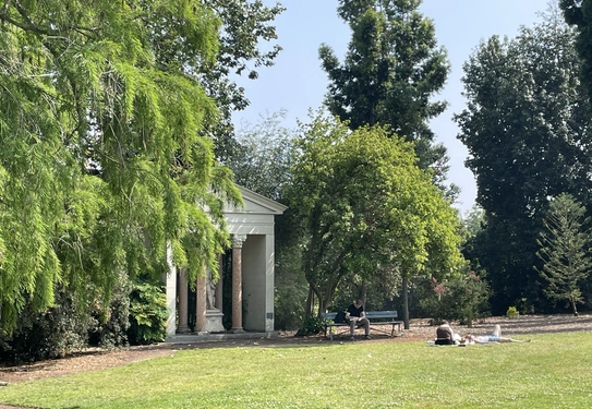 Visitors relax in front of a stone structure in the Australian Garden.