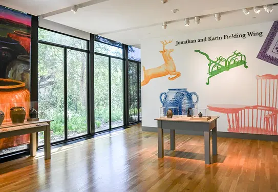 Stoneware on display in a window-lit museum space.