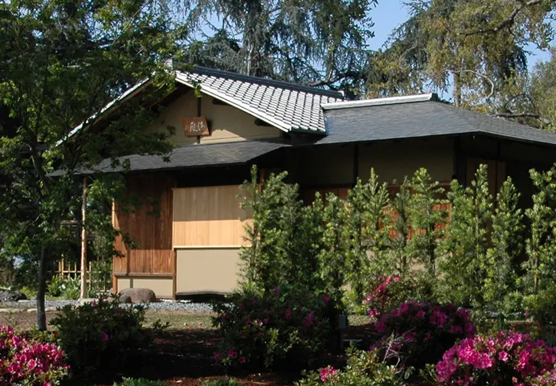 Small house-like building surrounded by plants and rocks.