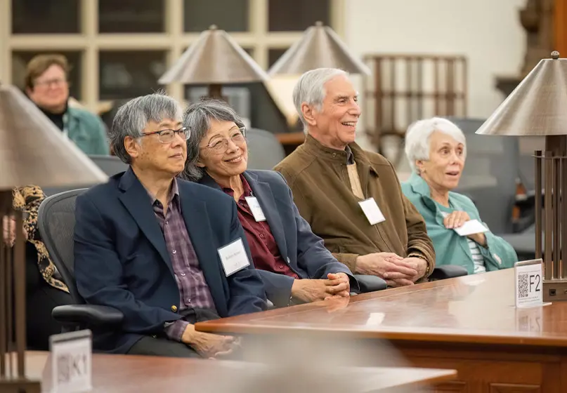 Four smiling people sit at a table.