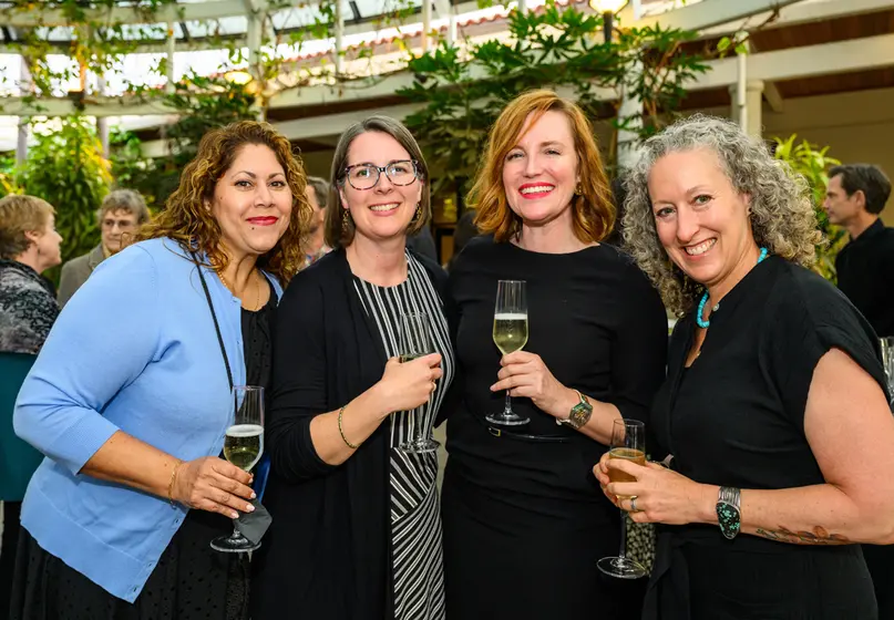 Four smiling people pose for a photo.