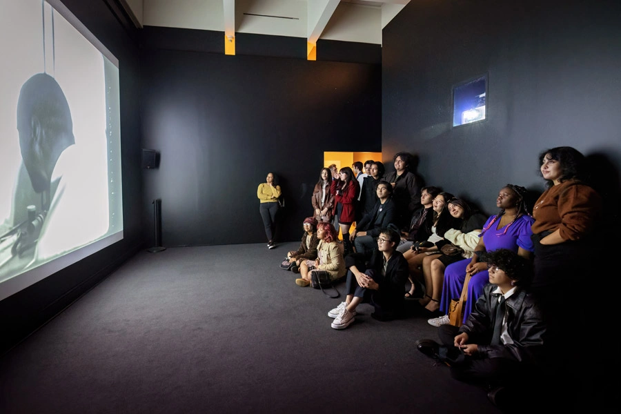 Ghetto Film School participants watch a film inside the Scott Galleries.