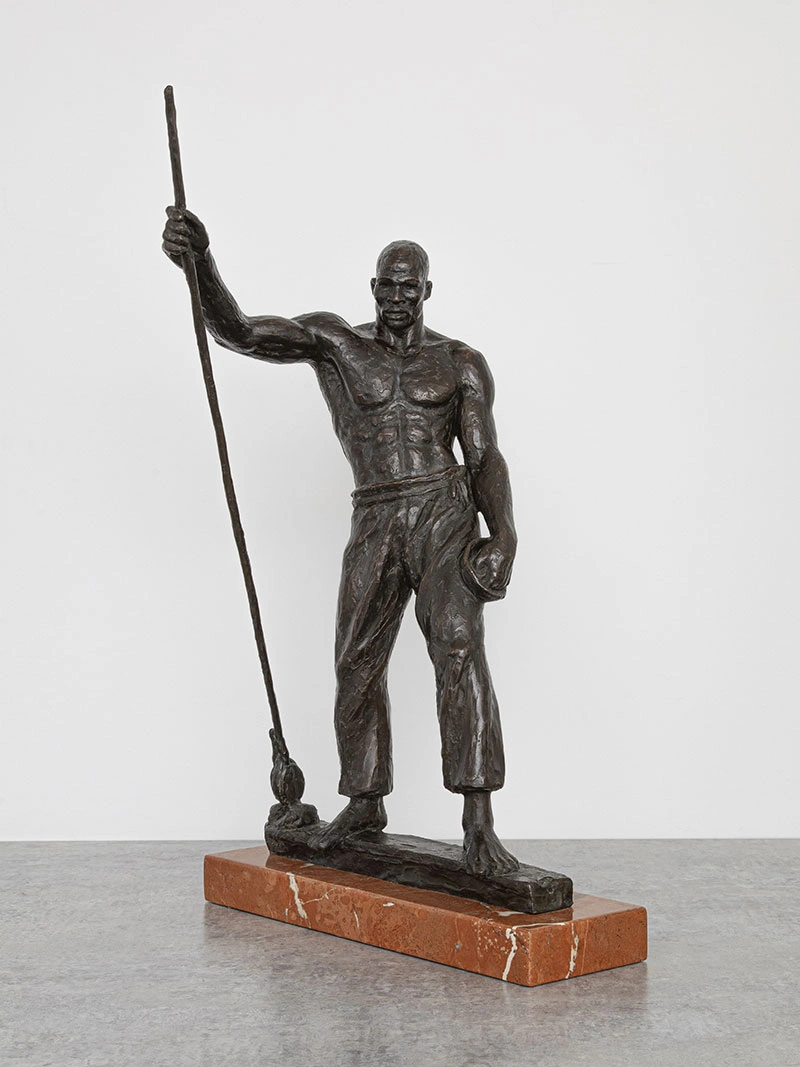 Small bronze sculpture of a muscular man holding a staff.