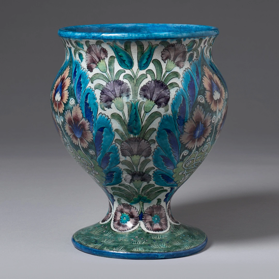 A ceramic vase with a multicolored, stylized botanical motif.