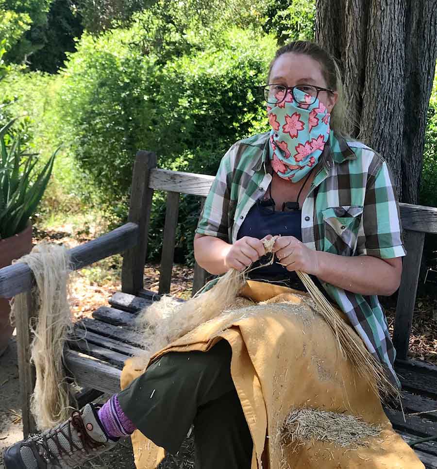 Alicia Baugh, a plant propagator at The Huntington, helps break flax by hand. Photo by Kelly Fernandez.